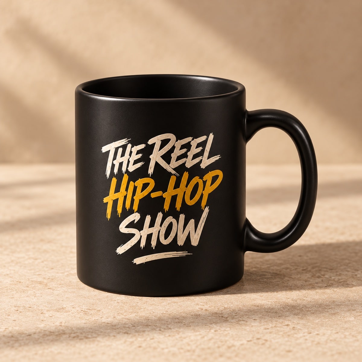 Original concept black mug with The Reel Hip Hop Show name in ivory and gold