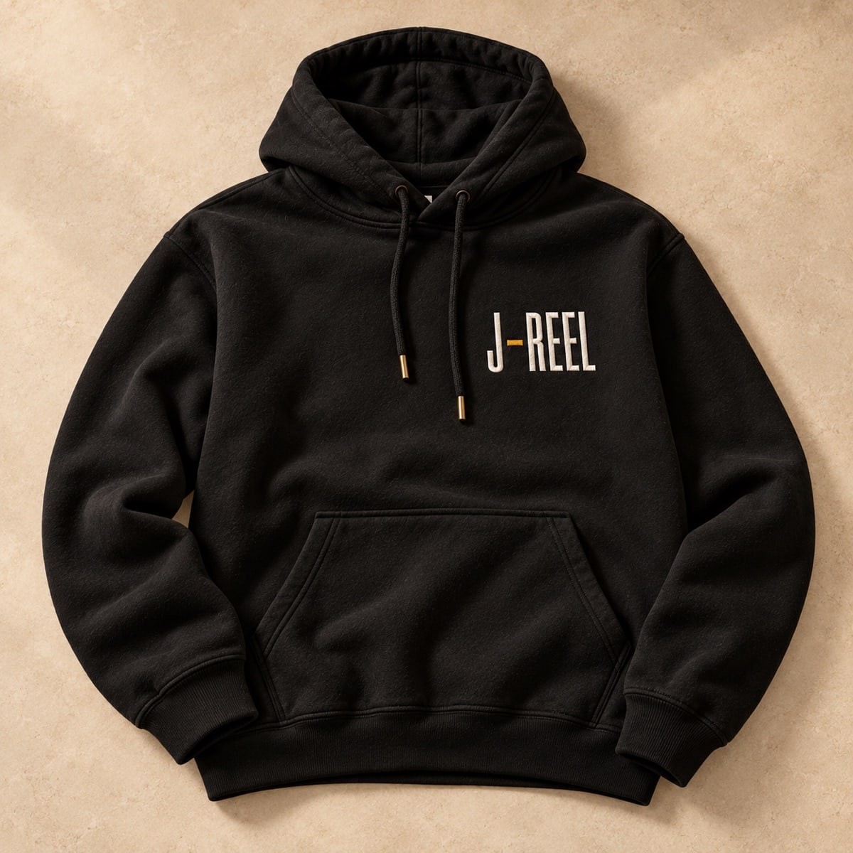Original concept black pullover hoodie with a small ivory and gold J-Reel chest mark
